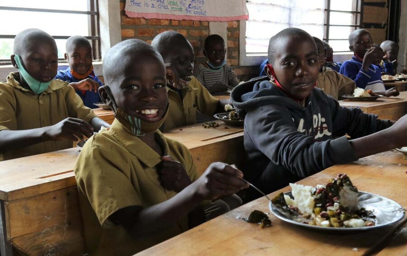Donat, aged 9, enjoys a WFP-supplied school meal with classmates