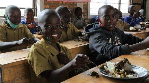 Donat, aged 9, enjoys a WFP-supplied school meal with classmates